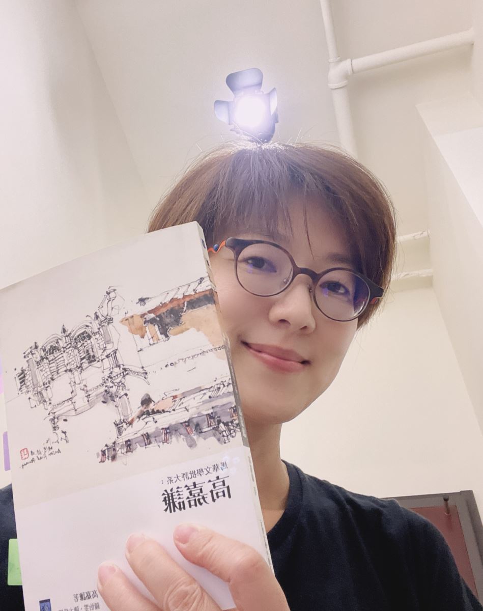Director Lin- Pei Lin holding book